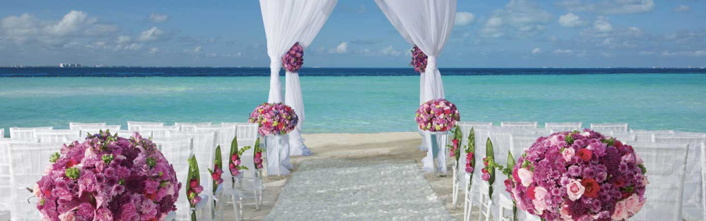 For a us-based couple interested in a destination wedding, why should they focus on all-inclusive resorts in Mexico, the Caribbean, Central America and beyond, and why should they use a travel agent for this 