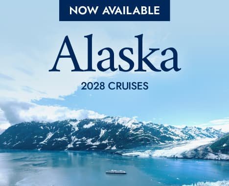Holland America ship sailing past Alaska glaciers and snow capped peaks