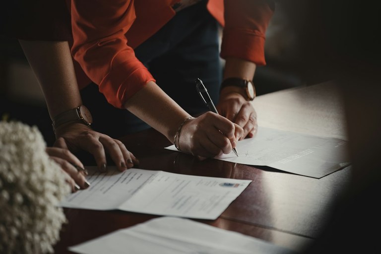 Corporate officer and travel advisor reviewing hotel group master contract attrition clauses and cut-off dates