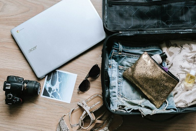 Traveler preparing a suitcase with a niche destination packing checklist, passport, and luxury itinerary guide
