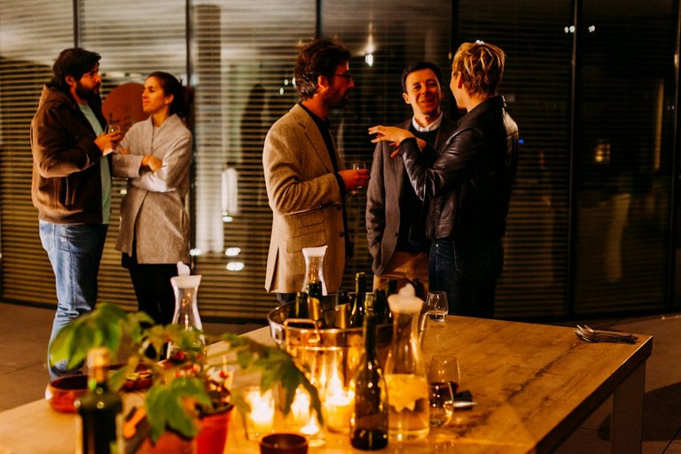 Three complementary local business owners co-hosting an upscale House Party client event for affluent guests