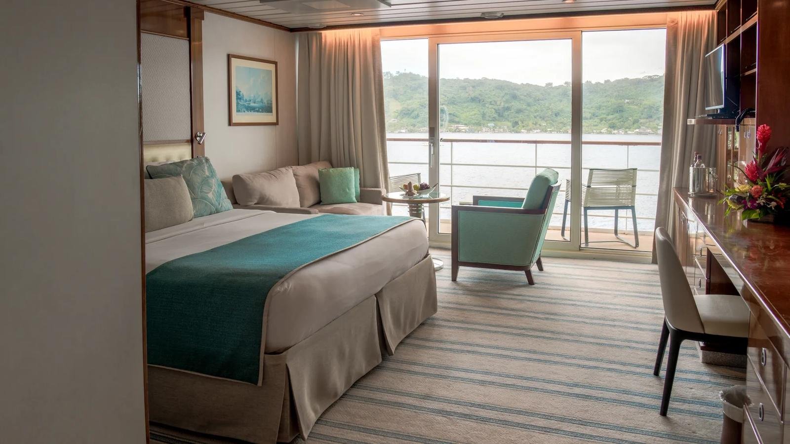 Category A Veranda Suite living lounge with sofa and balcony access on Paul Gauguin