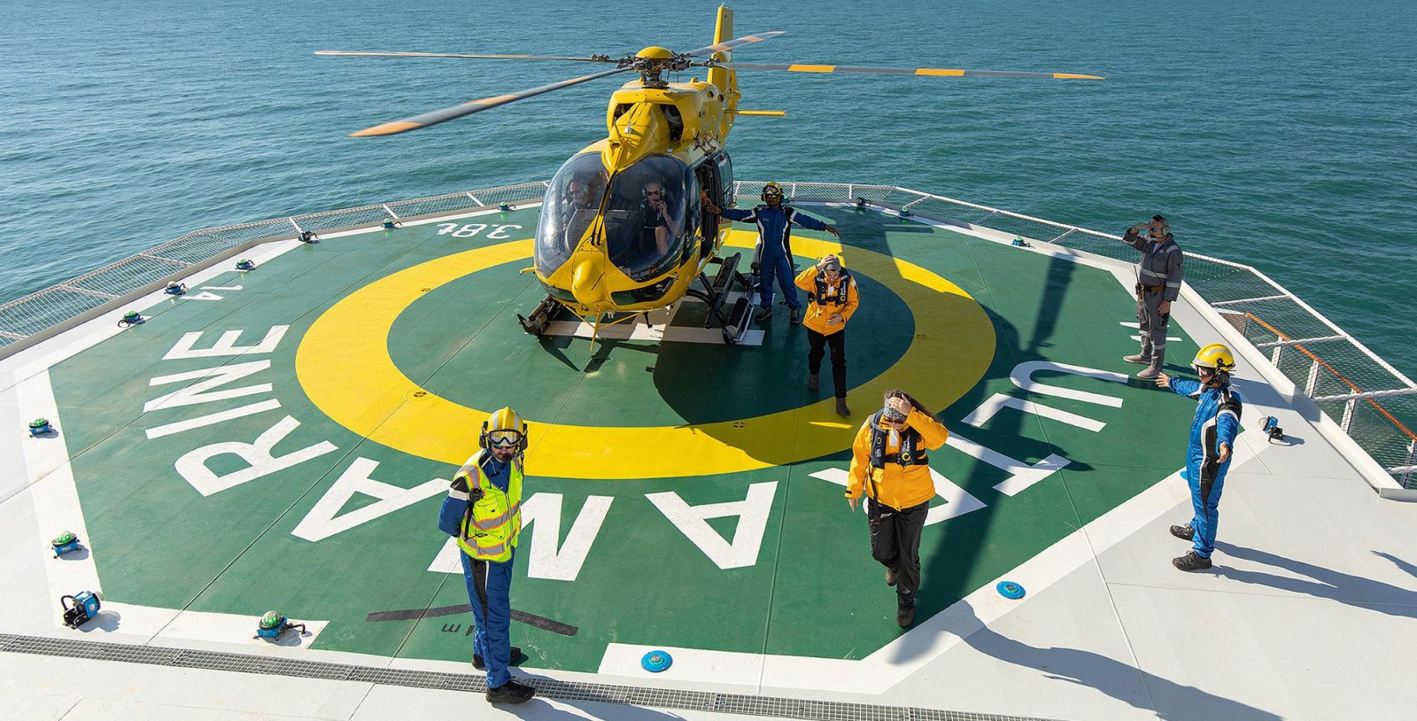 Quark Ultramarine Airbus H145 helicopter taking off over Antarctic ice shelf