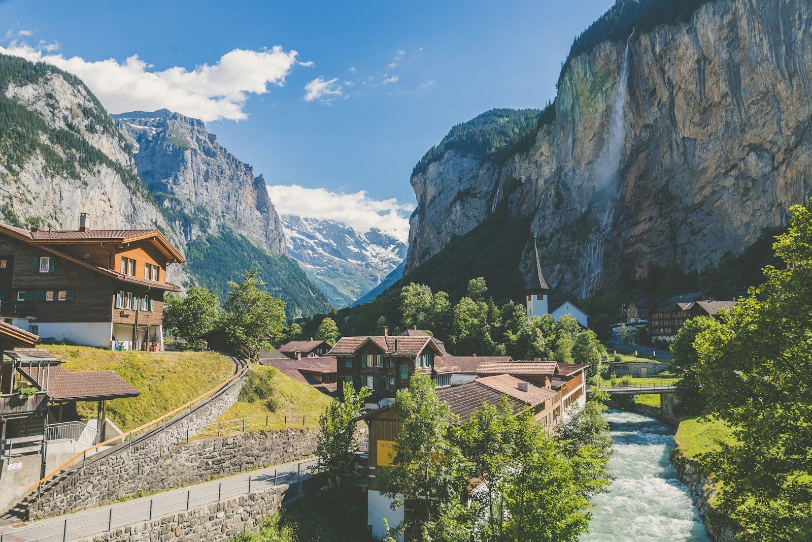 Panoramic red train traversing dramatic alpine stone viaduct in the Swiss Alps
