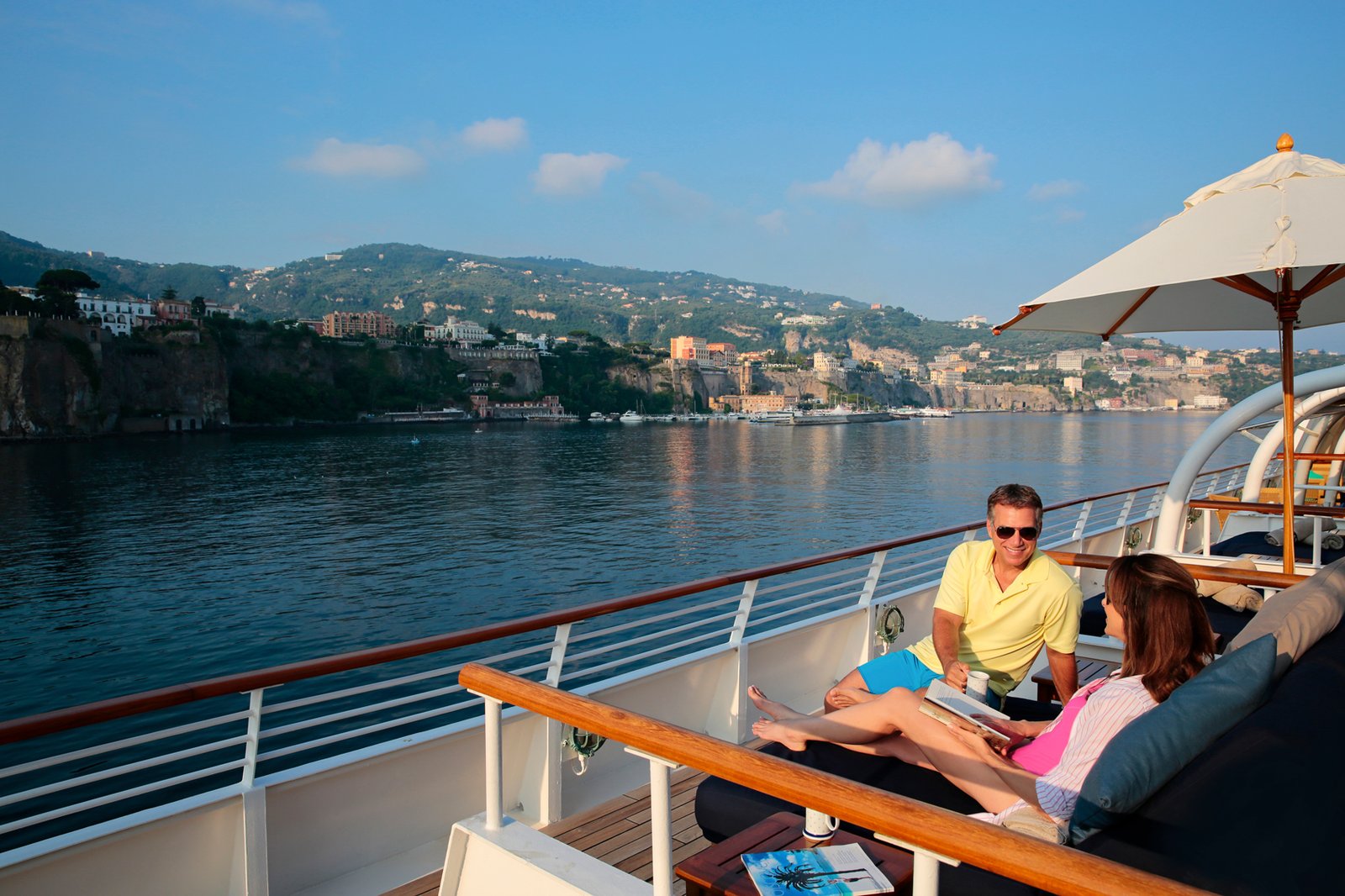 Guests lounging on iconic plush Balinese Dream Beds overlooking open ocean waters