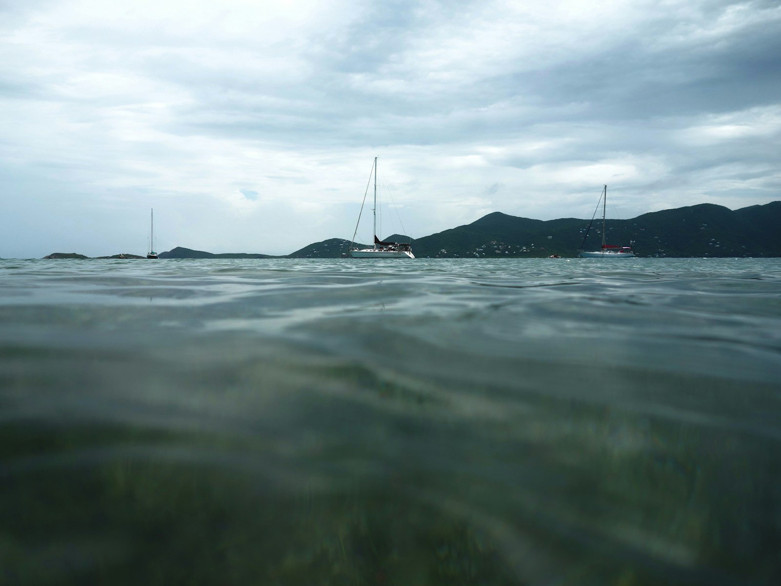 Sailboats anchored peacefully in a clear bay in St. John in the US Virgin Islands