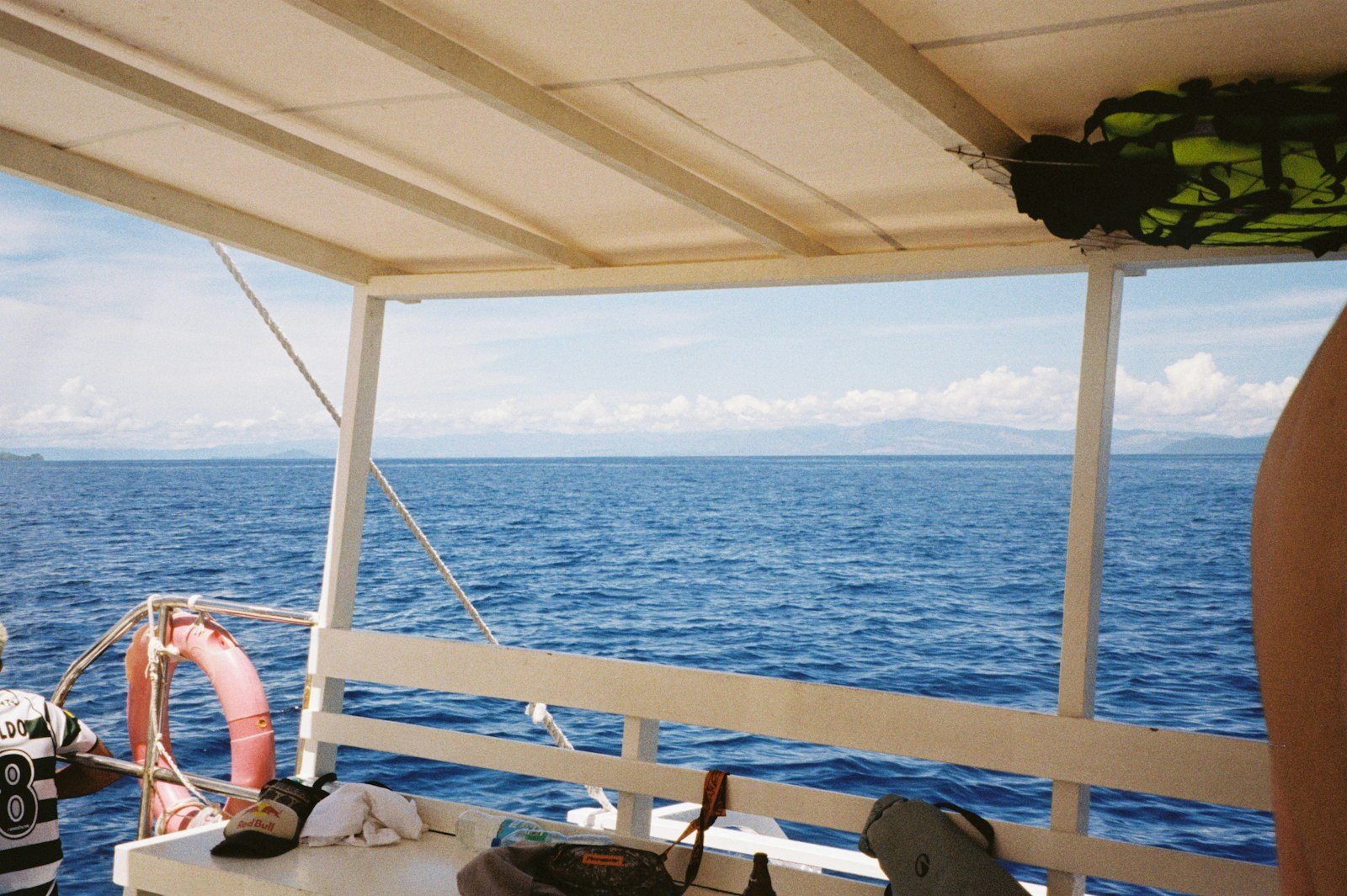 View from the forward deck and bow trampolines of a catamaran looking out over the open ocean