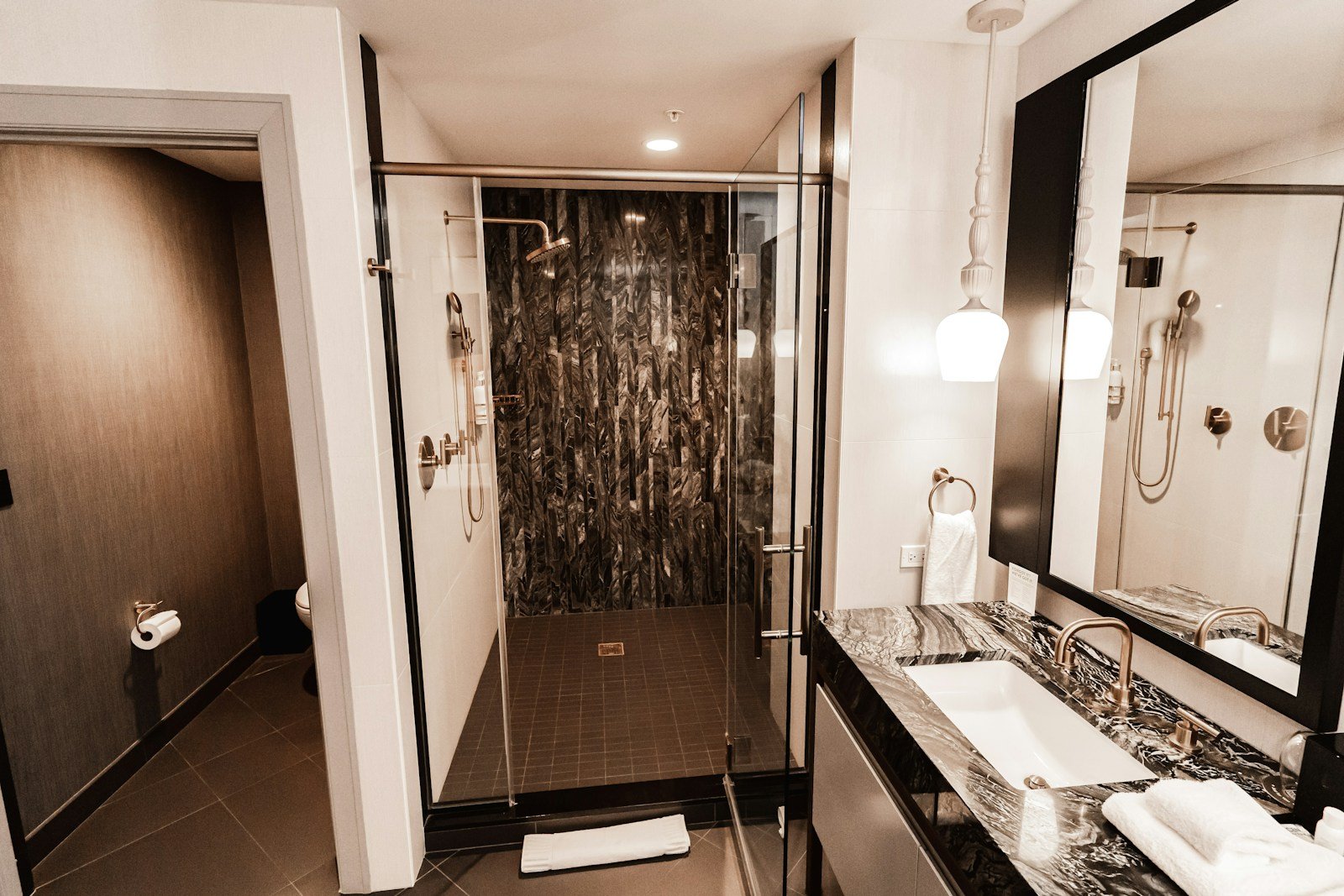 Spacious marble shower with overhead rainfall showerhead in a Uniworld Grand Suite