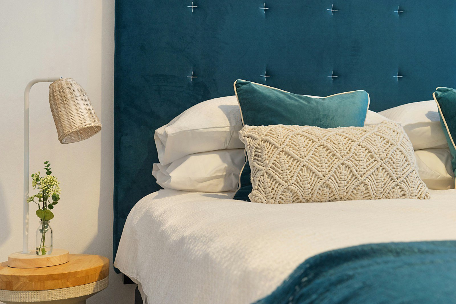 Handcrafted luxury bed with plush custom velvet headboard and fine European linens