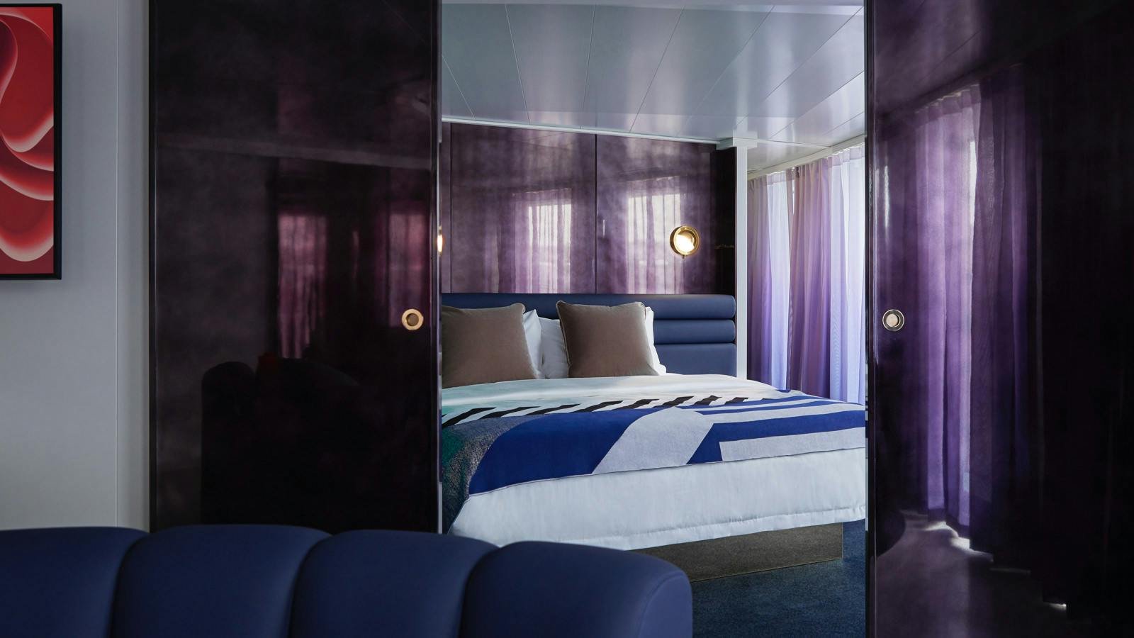 Official Virgin Voyages Massive Suite master bedroom with king bed and brass reading lights