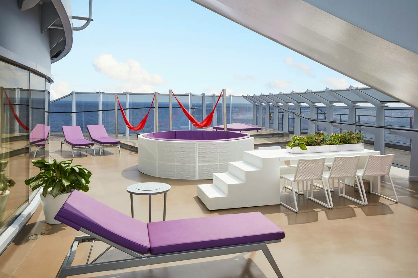 Official Virgin Voyages Massive Suite terrace showing runway dining table and red hammocks