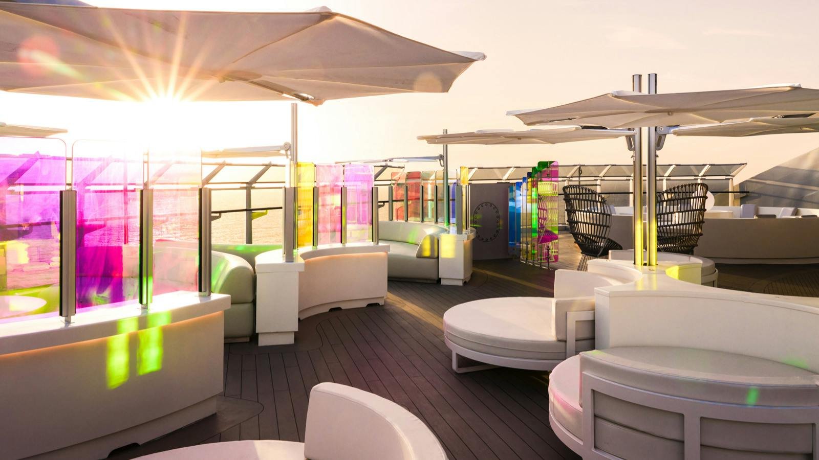 Official Virgin Voyages Richard's Rooftop VIP sundeck at golden hour with daybeds and iridescent glass